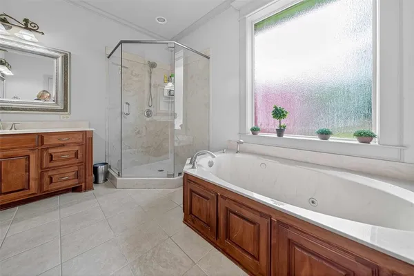 a spacious bathroom with a tub sink and mirror