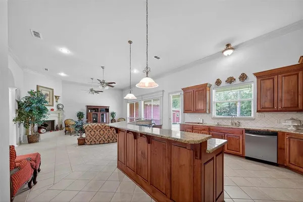 a kitchen with kitchen island granite countertop a sink a counter top space appliances and cabinets