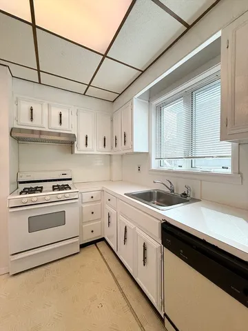 a kitchen with stainless steel appliances granite countertop a sink a stove and cabinets