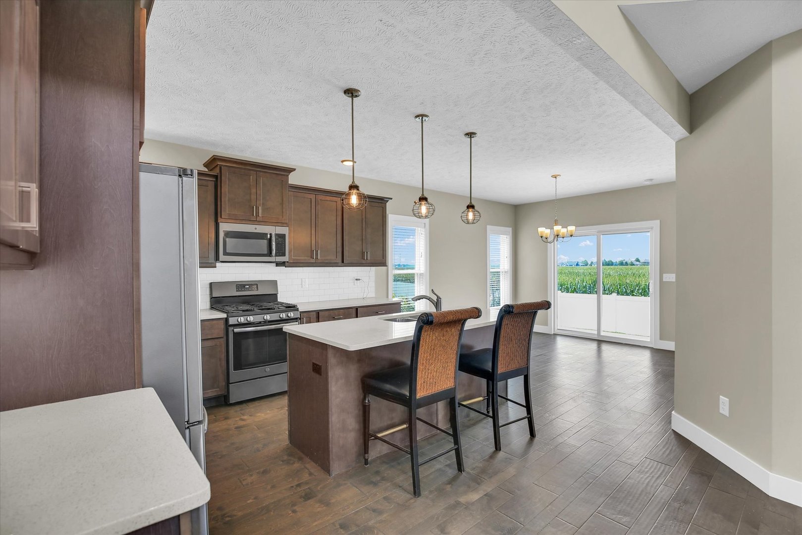 5008 Emmas Way Champaign, IL 61822 - Photo 12 of 53 a kitchen with stainless steel appliances granite countertop a stove a refrigerator a oven a sink with a dining table and chairs
