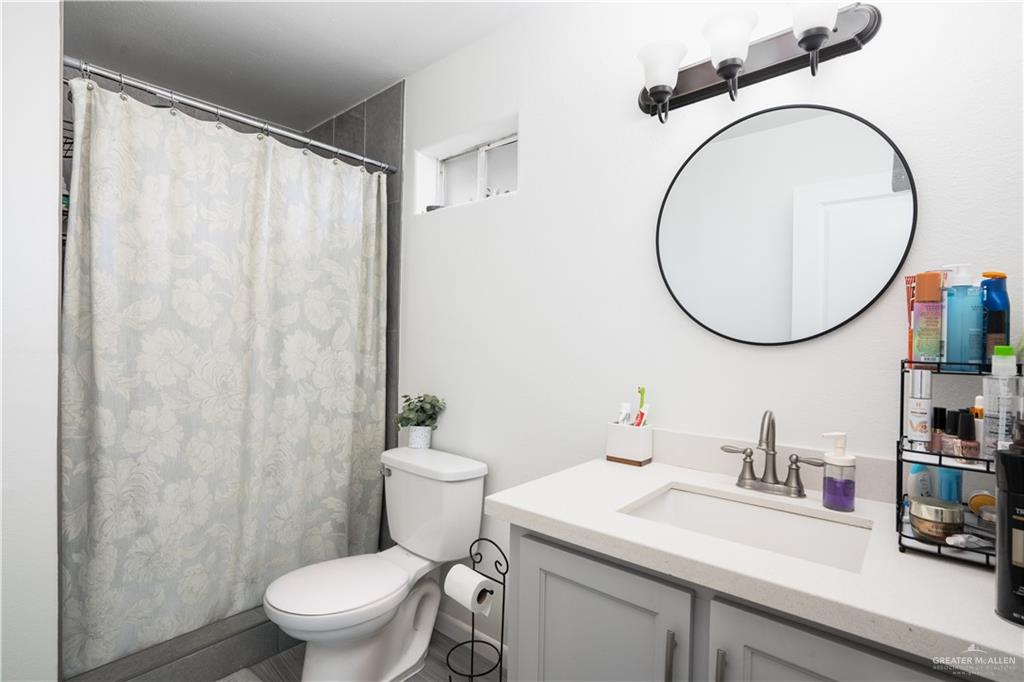 32516 El Preseno Road San Benito, TX 78586 - Photo 14 of 45 a bathroom with a sink a toilet and a mirror