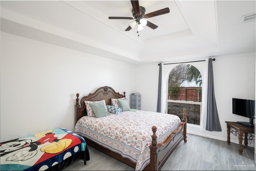 32516 El Preseno Road San Benito, TX 78586 - Photo 16 of 45 a bedroom with a bed a chandelier and a window