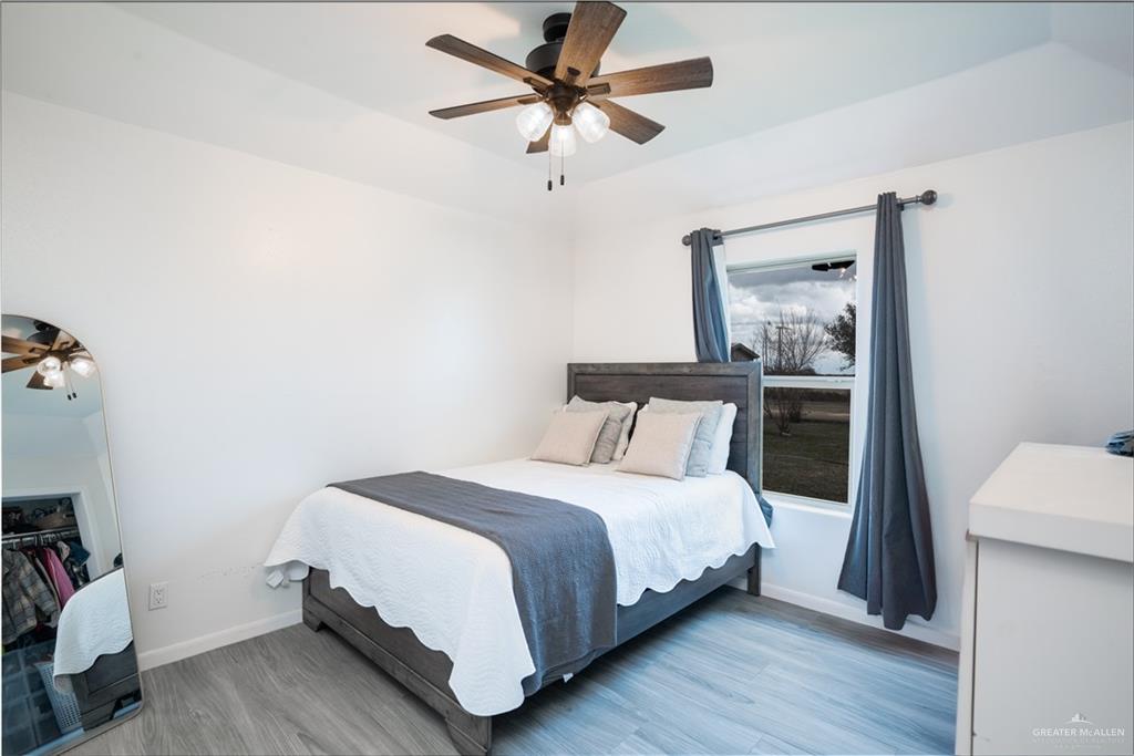 32516 El Preseno Road San Benito, TX 78586 - Photo 20 of 45 a bedroom with a bed and a chandelier