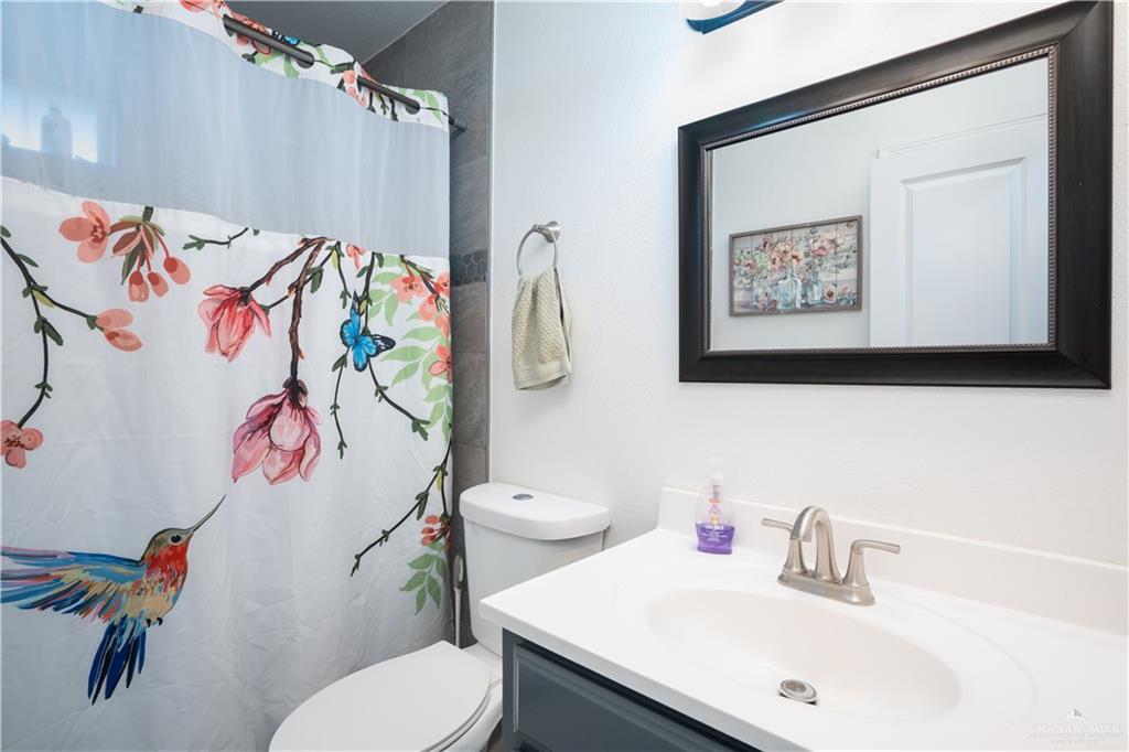 32516 El Preseno Road San Benito, TX 78586 - Photo 21 of 45 a bathroom with a sink vanity mirror and toilet