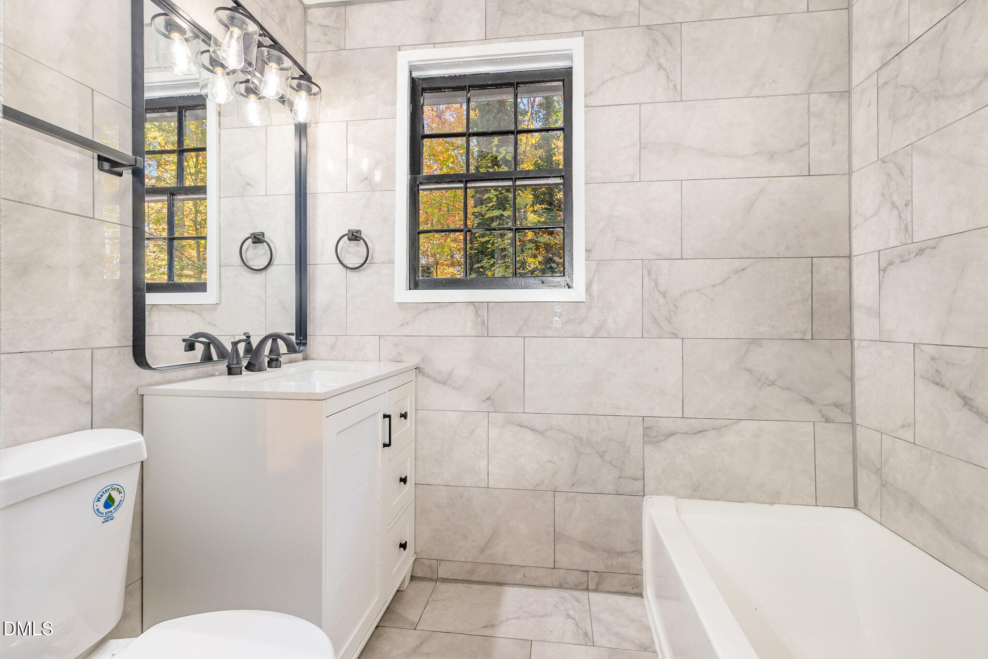 608 Dennis Avenue Raleigh, NC 27604 - Photo 15 of 30 a bathroom with a sink a mirror a toilet and a shower