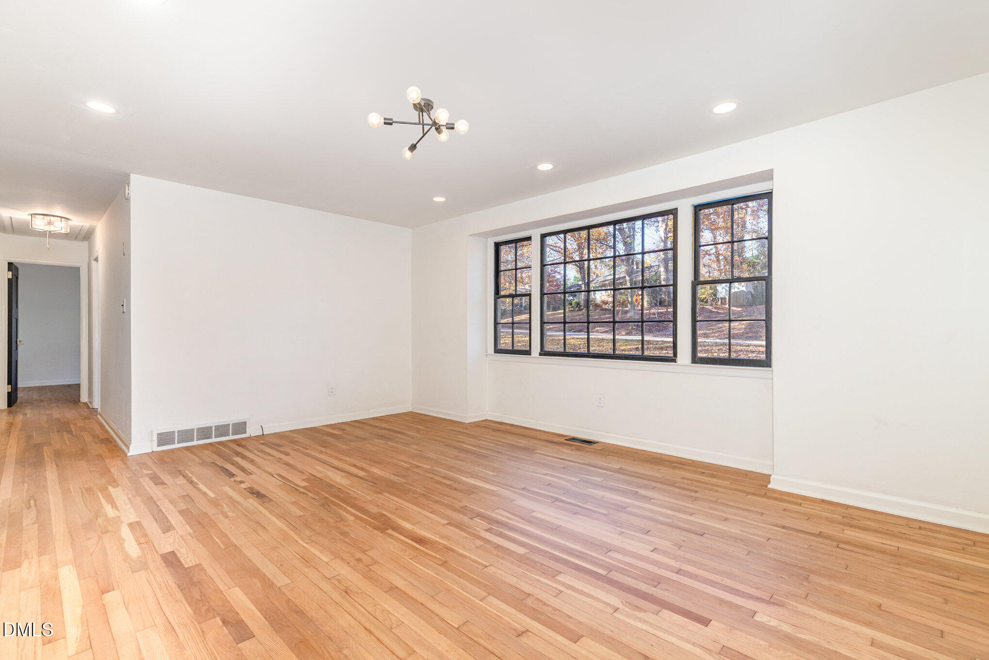 608 Dennis Avenue Raleigh, NC 27604 - Photo 6 of 30 a view of an empty room with wooden floor and a window