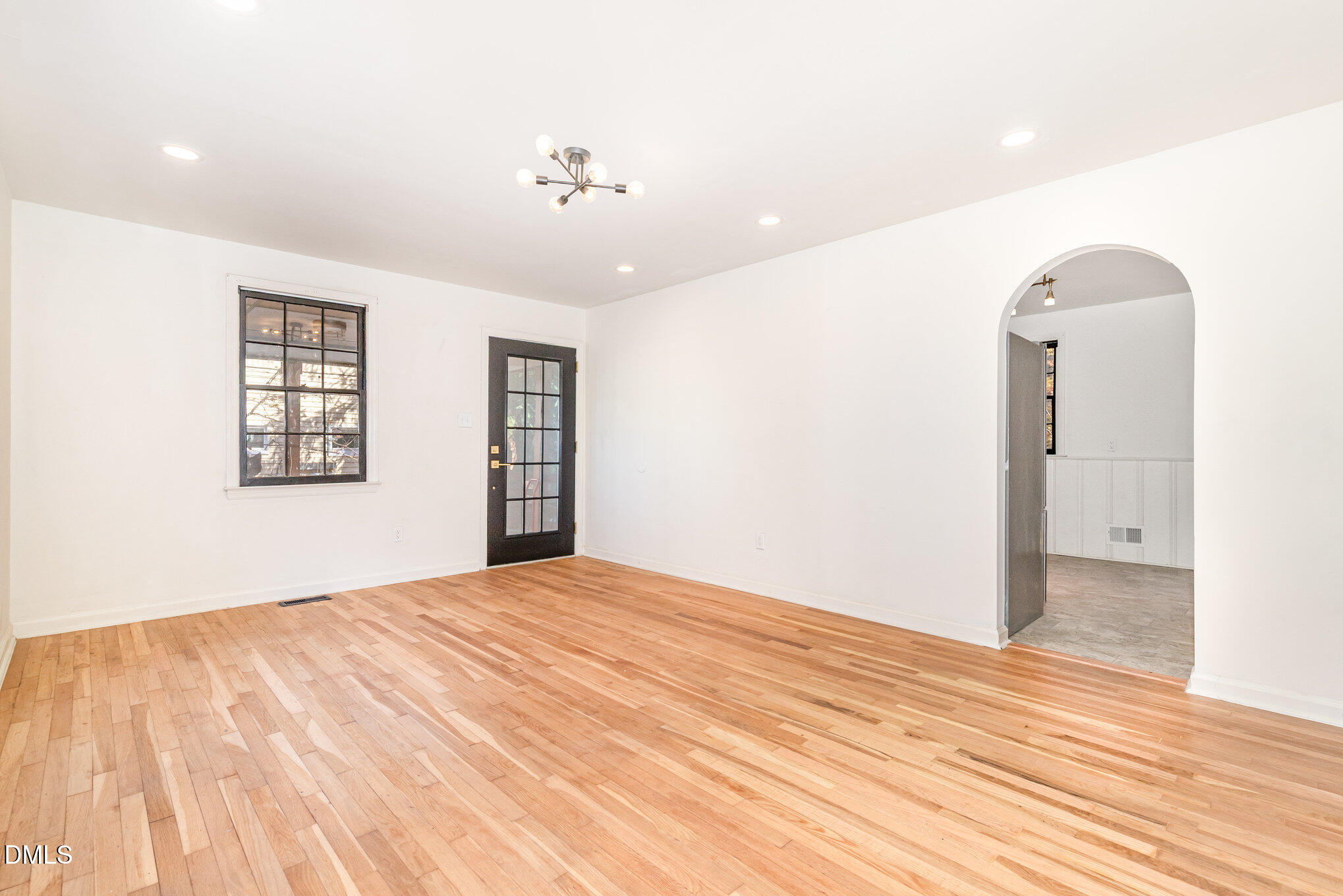 608 Dennis Avenue Raleigh, NC 27604 - Photo 7 of 30 a view of an empty room with wooden floor and a window