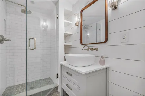 a bathroom with a sink vanity and shower