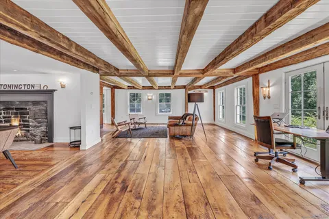 a view of a livingroom with furniture wooden floor and windows