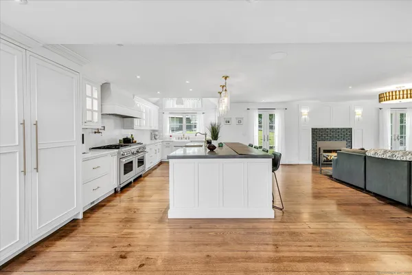 a large kitchen with stainless steel appliances kitchen island granite countertop a large counter top and a stove top oven