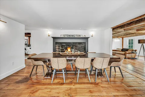 a view of a dining room with furniture a rug and wooden floor