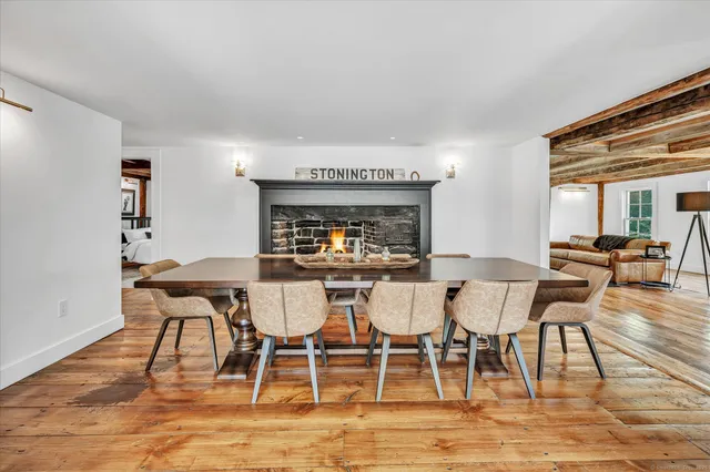a view of a dining room with furniture a rug and wooden floor