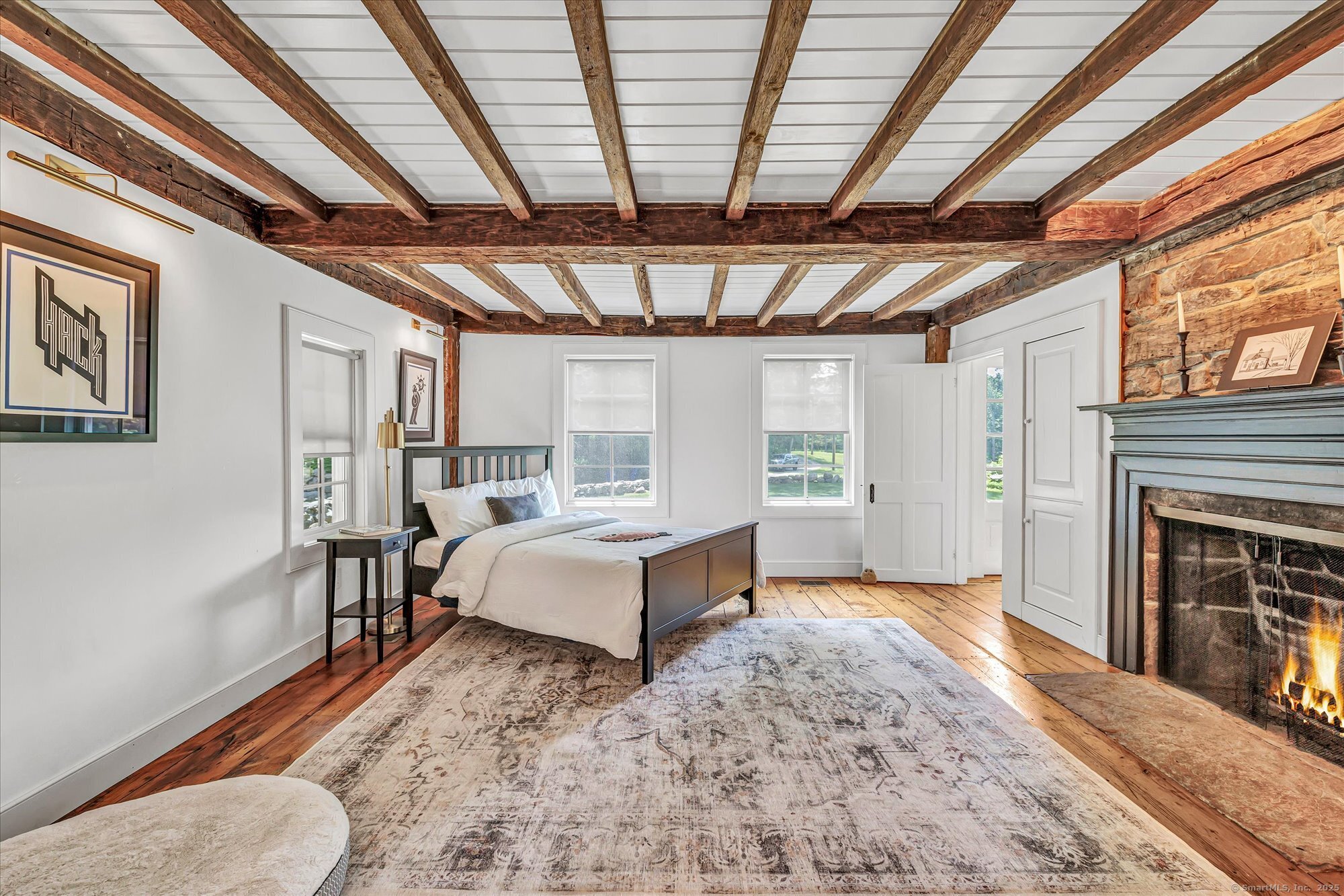 188 Wolf Neck Road Stonington, CT 06378 - Photo 19 of 40 a spacious bedroom with a bed and a fireplace