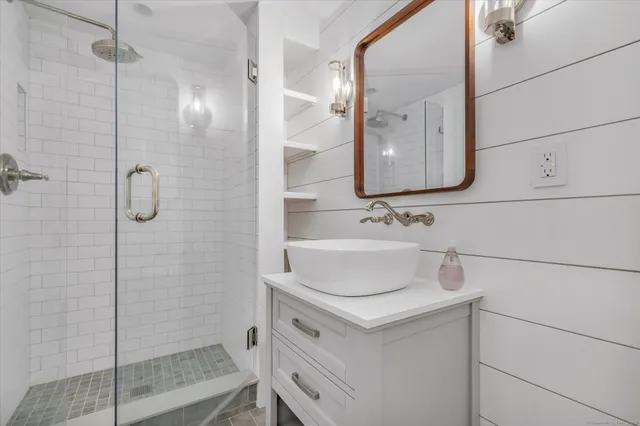 a bathroom with a sink vanity and shower