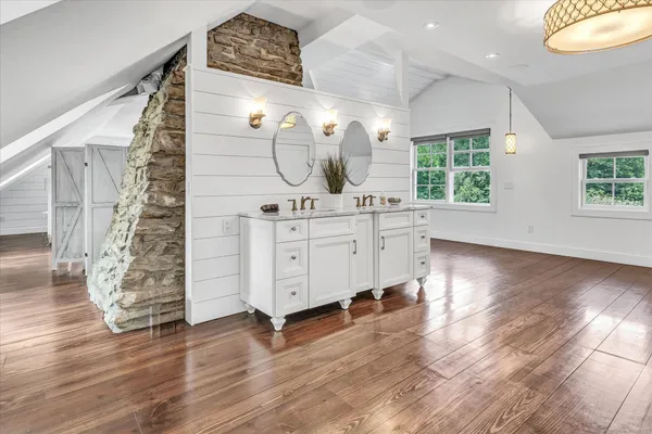 a view of a bedroom with wooden floor windows and a chandelier