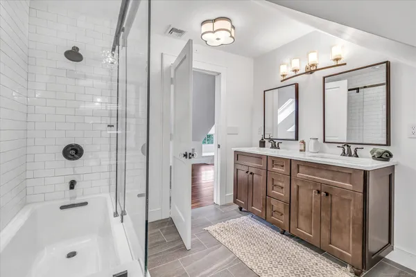 a bathroom with a double vanity sink mirror and shower