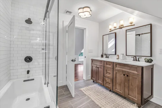 a bathroom with a double vanity sink mirror and shower
