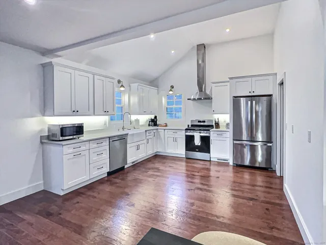 a kitchen with a refrigerator cabinets and wooden floor