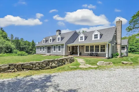 a view of a house with a yard and sitting area
