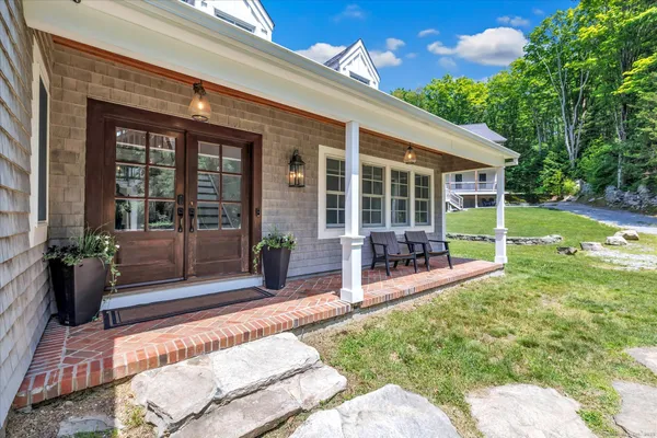 a view of a house with backyard porch and sitting area
