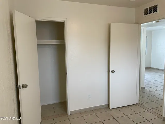 a view of walk in closet with empty racks