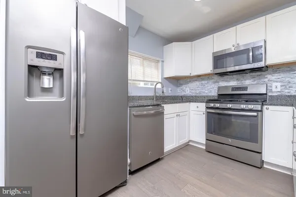 a kitchen with stainless steel appliances white cabinets and a stove