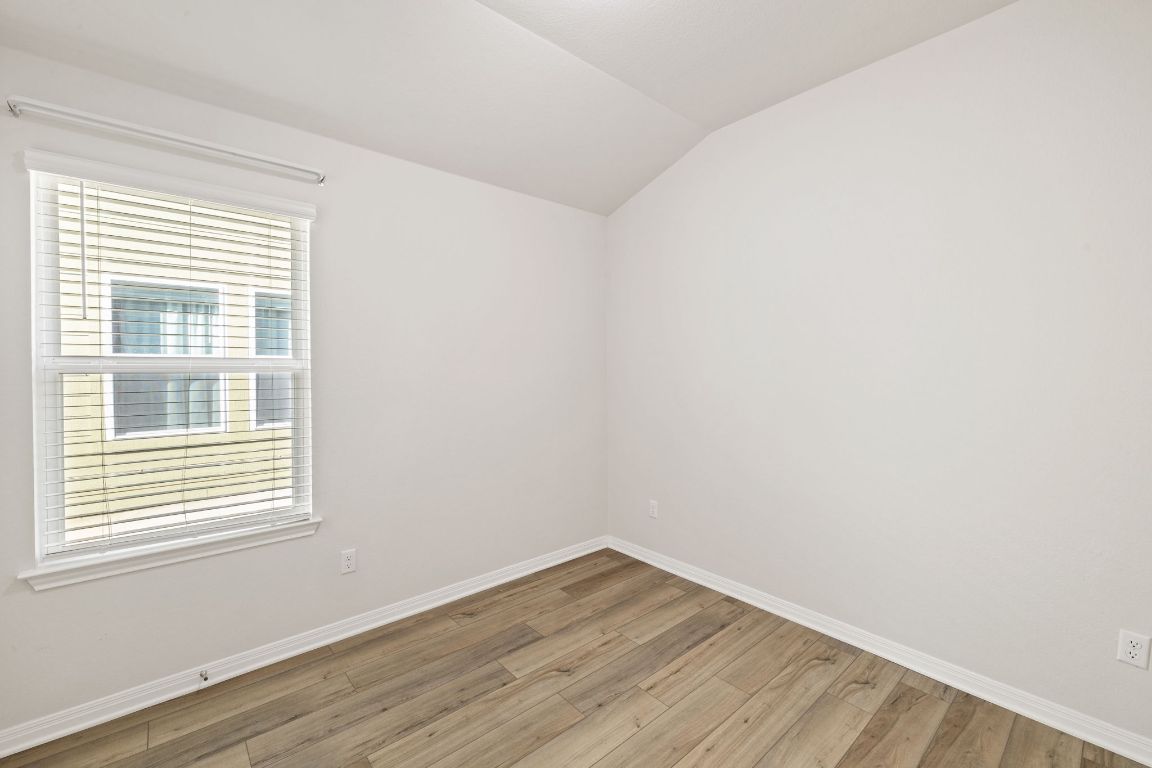 700 Autumn Stem Place Austin, TX 78748 - Photo 11 of 36 a view of an empty room with wooden floor and a window