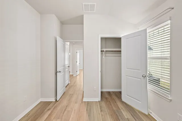 a view of hallway with a large window and wooden floor