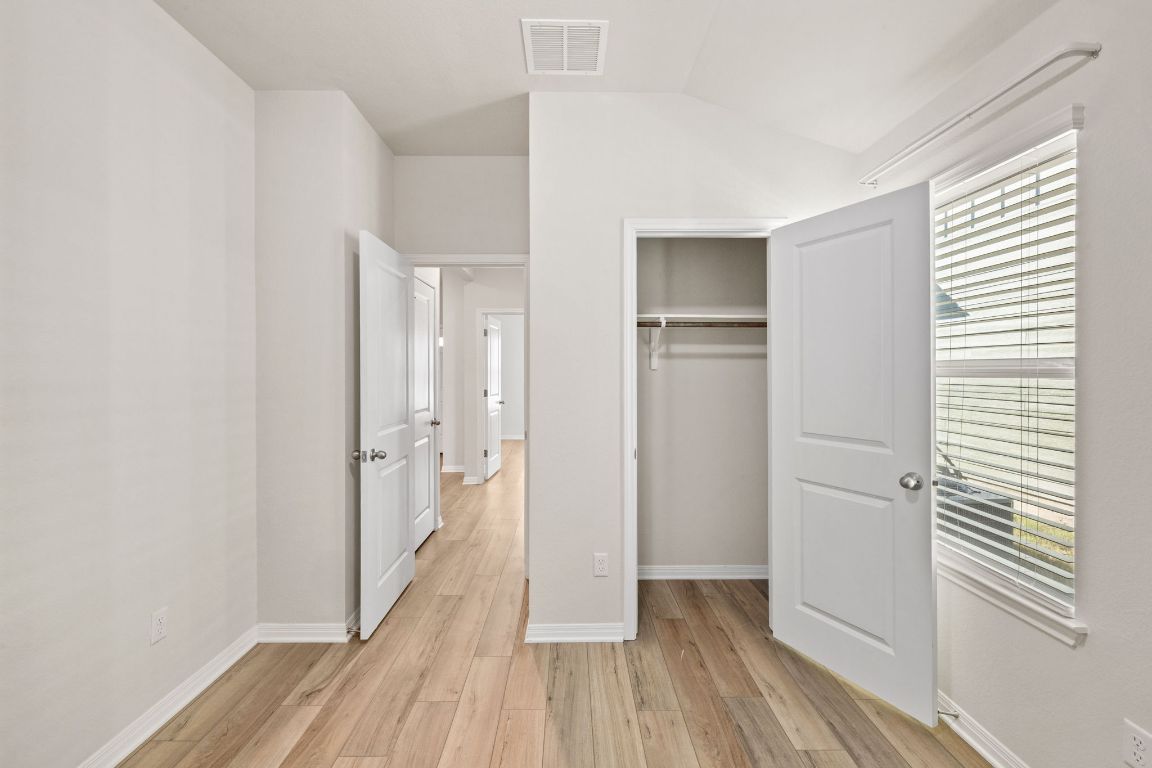 700 Autumn Stem Place Austin, TX 78748 - Photo 13 of 36 a view of hallway with a large window and wooden floor