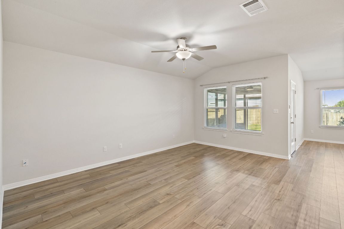 700 Autumn Stem Place Austin, TX 78748 - Photo 21 of 36 an empty room with wooden floor chandelier fan and windows