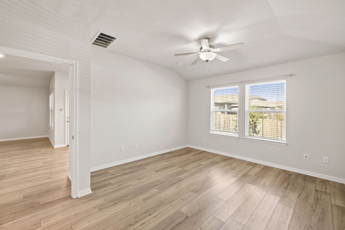 700 Autumn Stem Place Austin, TX 78748 - Photo 26 of 36 a view of an empty room with wooden floor and a window