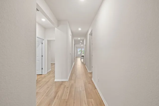 a view of a hallway with wooden floor