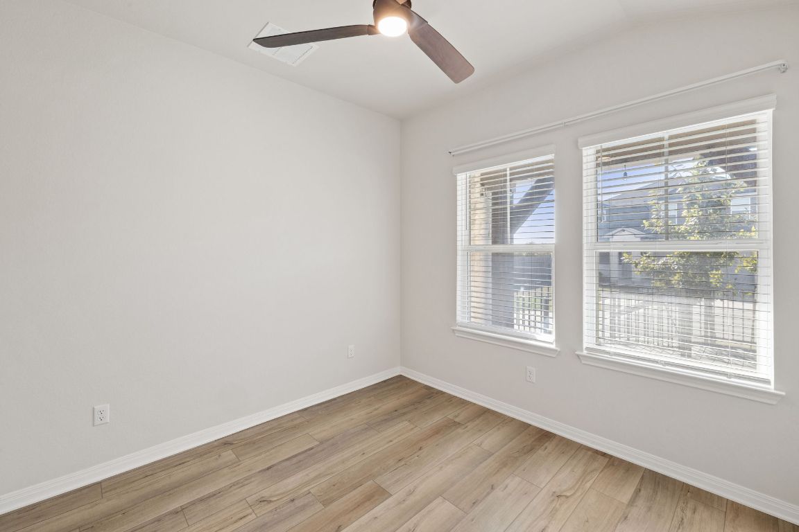 700 Autumn Stem Place Austin, TX 78748 - Photo 6 of 36 a view of an empty room with wooden floor and a window