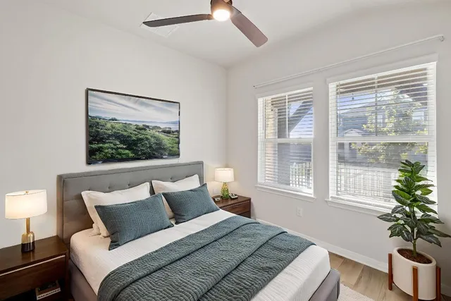 a bedroom with a large bed and a potted plant