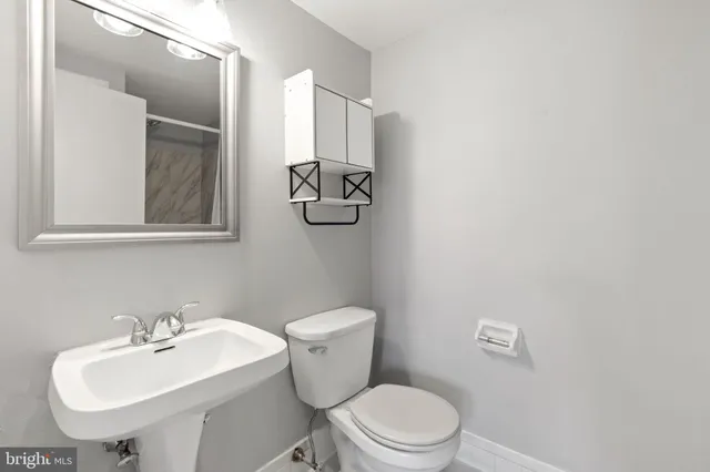 a bathroom with a toilet a sink and mirror