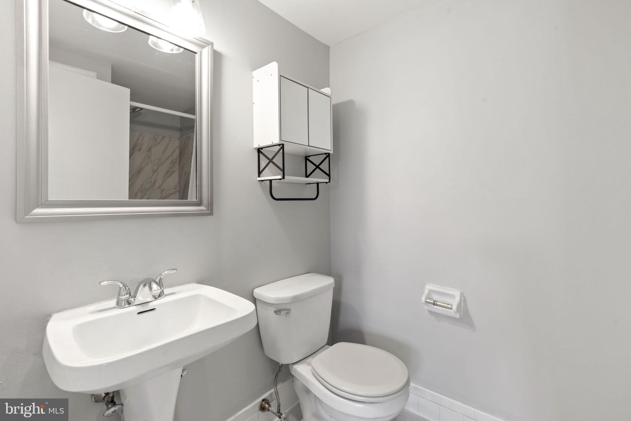 814 South Avenue, Unit J6 Secane, PA 19018 - Photo 11 of 15 a bathroom with a toilet a sink and mirror