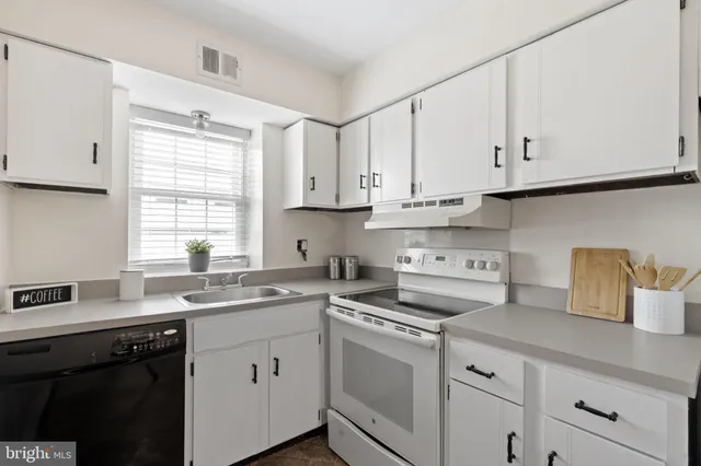 a kitchen with cabinets appliances a sink and a window