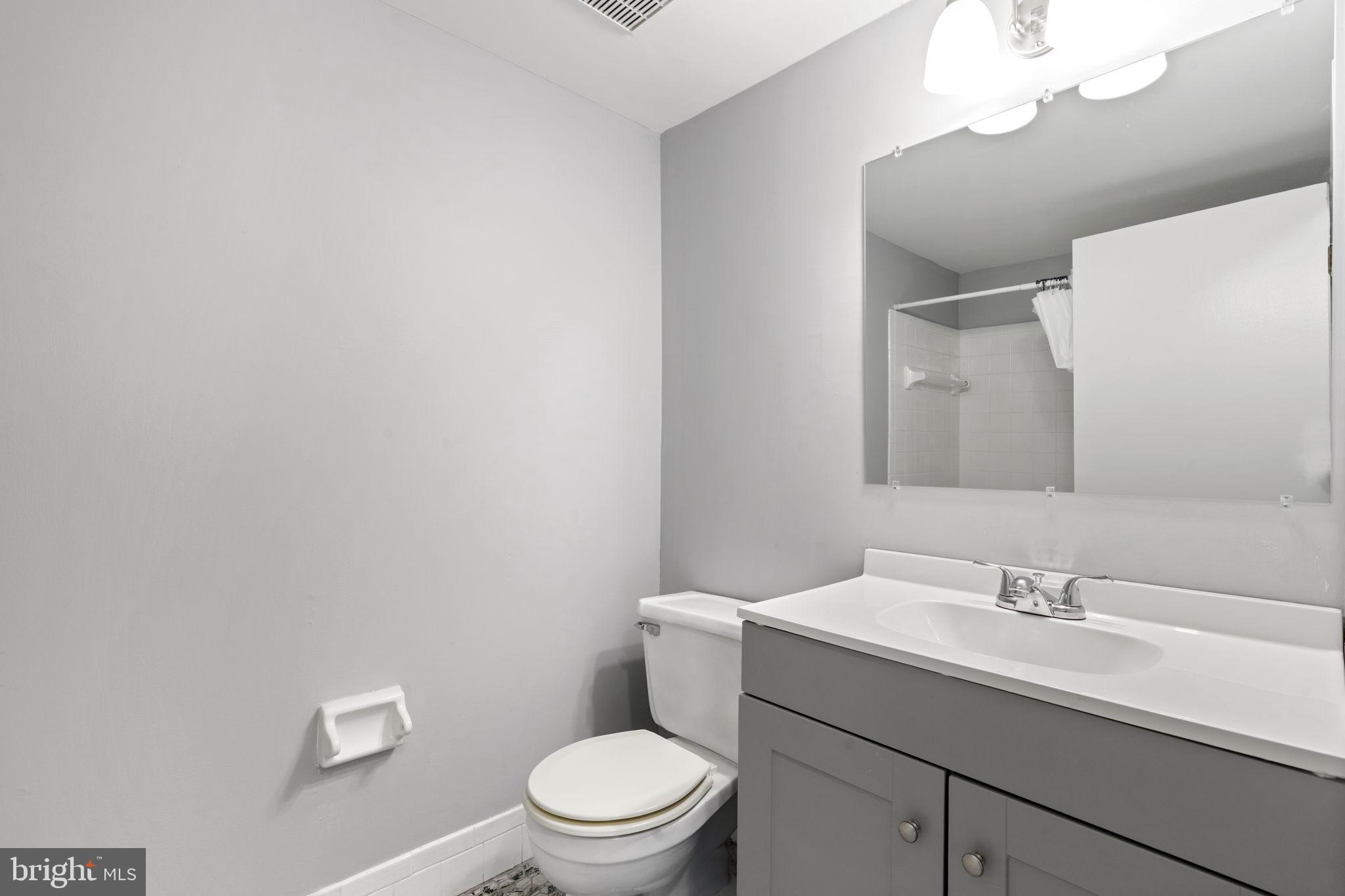 814 South Avenue, Unit J6 Secane, PA 19018 - Photo 7 of 15 a bathroom with a toilet a sink a mirror and vanity