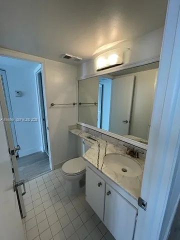 a bathroom with a sink mirror vanity and toilet