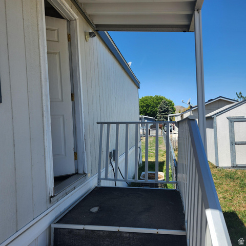 3760 Gold Ridge Drive, Unit 82 Magna, UT 84044 - Photo 5 of 29 Covered porch with white metal railings, vertical siding exterior, and an exterior light fixture