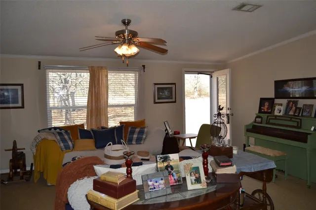 a living room with furniture a flat screen tv and a window
