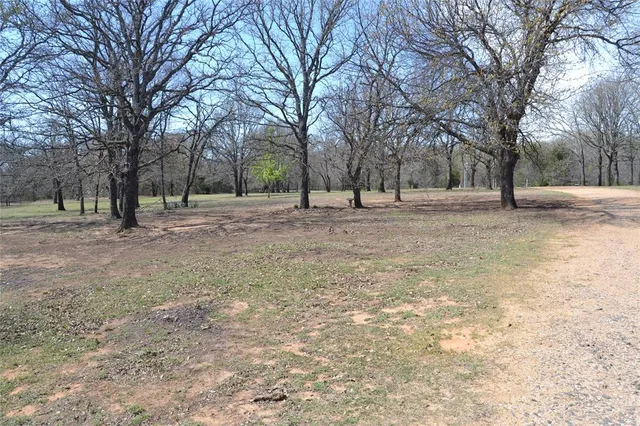 a view of dirt yard with a house