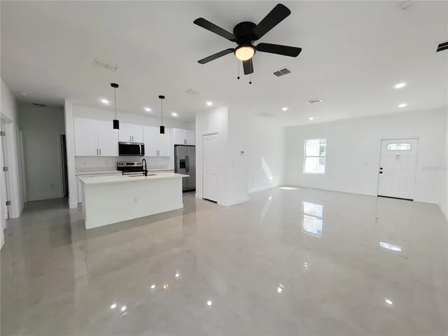a view of a kitchen with a sink and a stove top oven with wooden floor