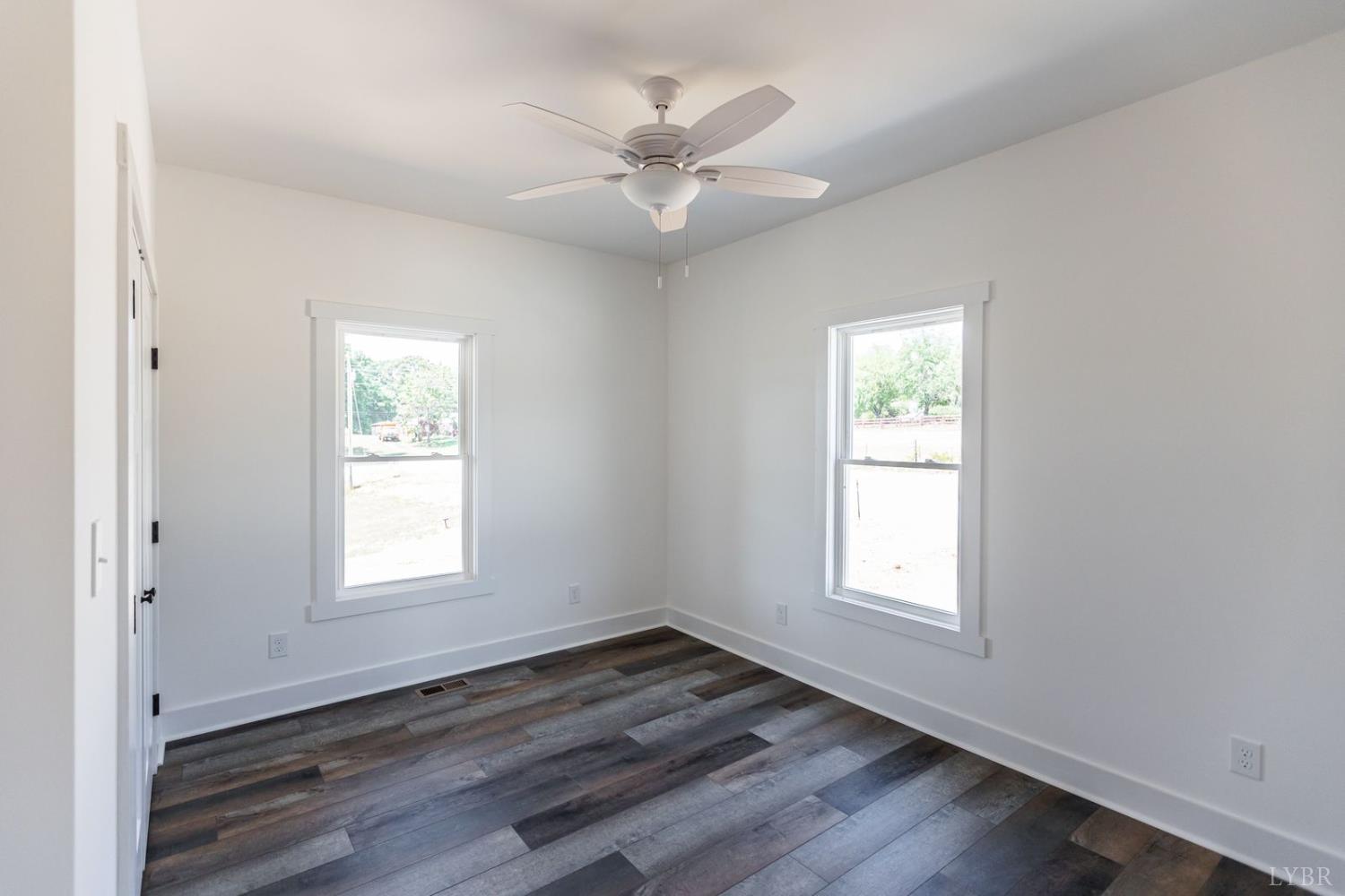 9740 Oakville Road Gladstone, VA 24553 - Photo 59 of 75 an empty room with wooden floor ceiling fan and windows