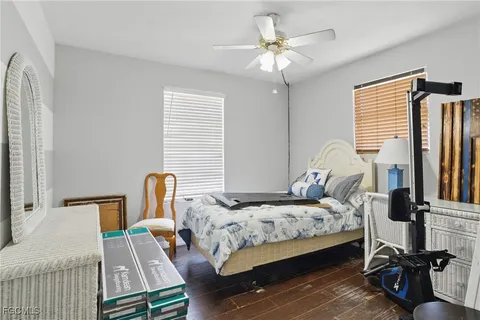 a bedroom with a bed wooden floor and a chandelier