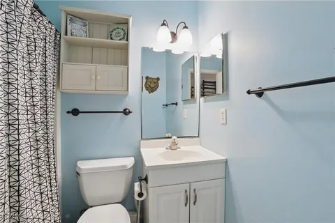 a bathroom with a toilet sink and mirror
