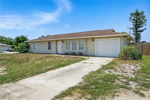 a front view of house with yard and trees around