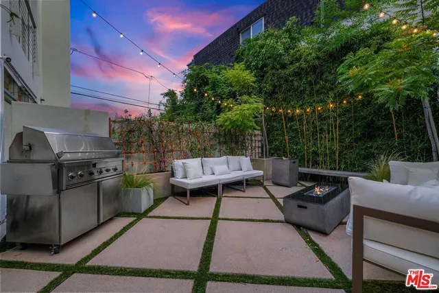 a view of a patio with couches table and chairs and potted plants