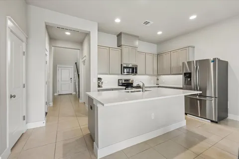 a kitchen with stainless steel appliances a refrigerator sink and microwave