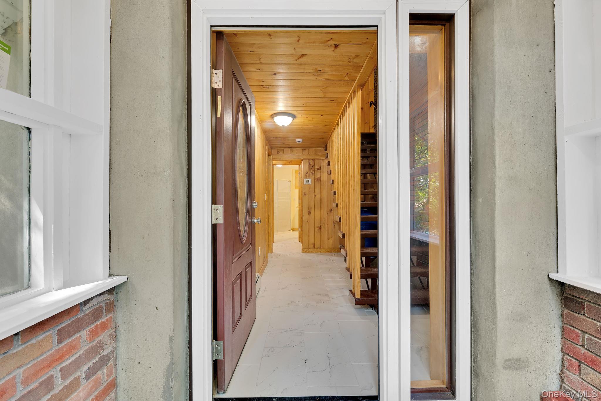 53 West Corbett Road Montgomery, NY 12549 - Photo 20 of 41 a view of a hallway with wooden floor and a dining room with windows